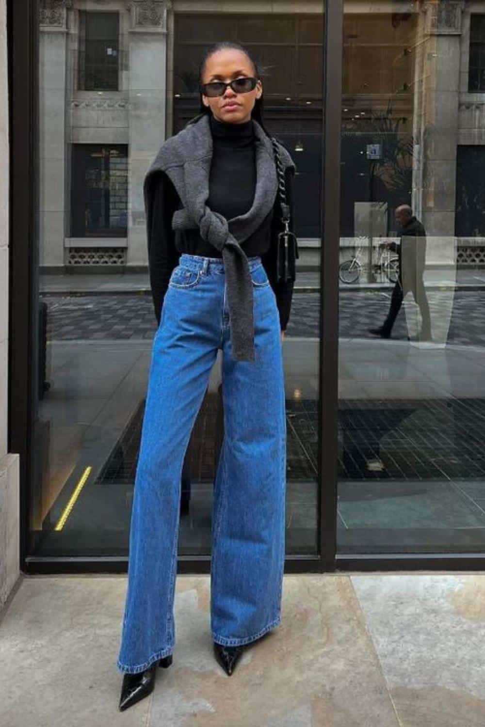 Blue wide leg jeans outfit with sweatshirt of the shoulder.