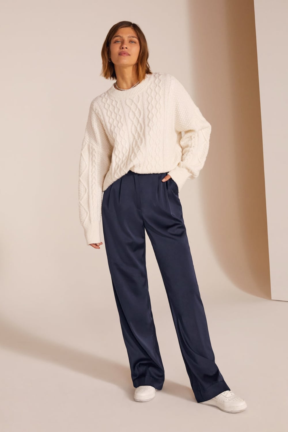 Satin pants outfit with cable knit sweater and white leather sneakers