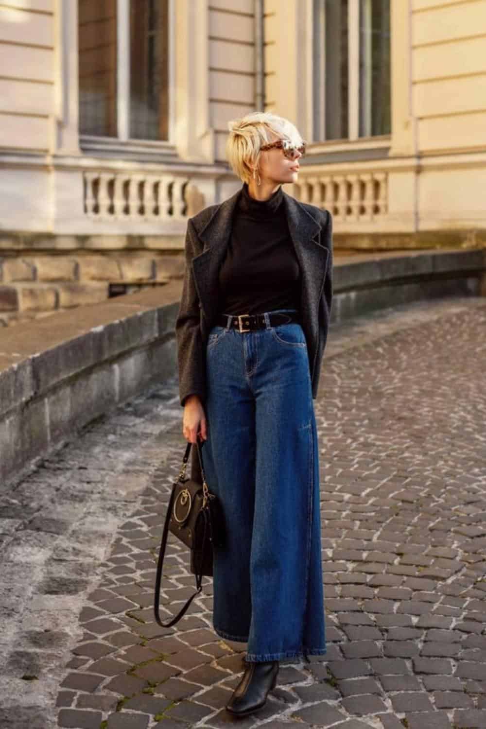 Blue wide leg jeans with black sweater and gray coat