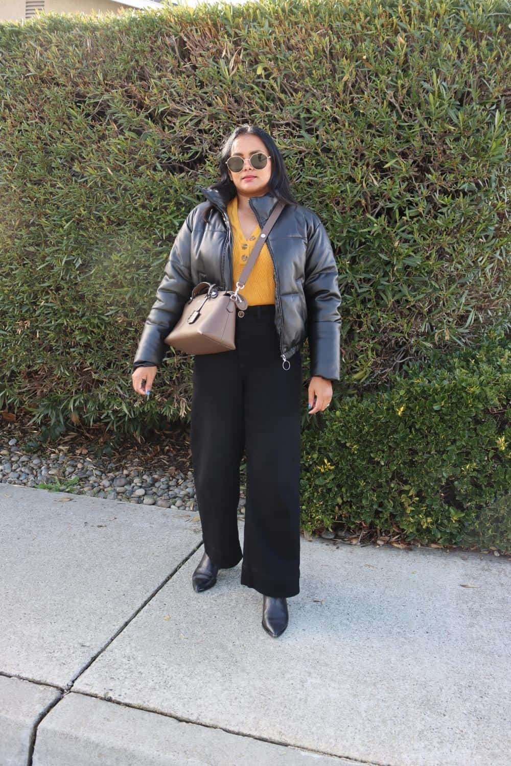Black wide leg jeans outfit with colored henley and faux leather puffer jacket