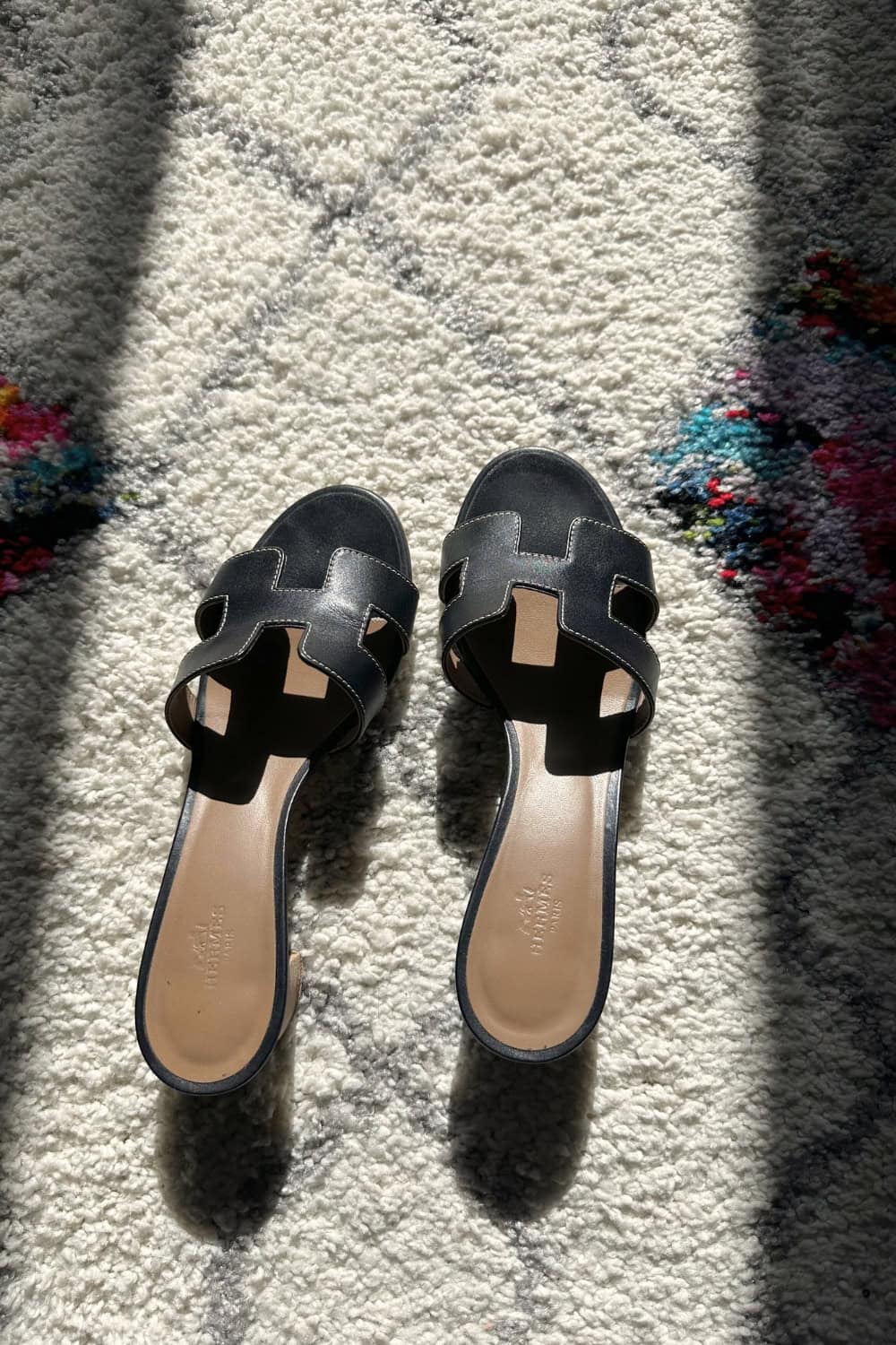 a pair of black sandals on a carpet