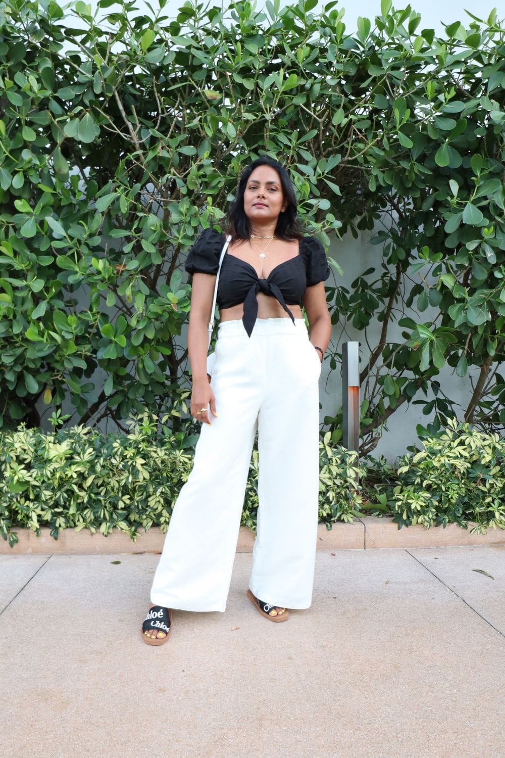 what-to-wear-in-miami-Black-Top-with-Feminine-Details-White-Linen-Pants-Designer-Sandals